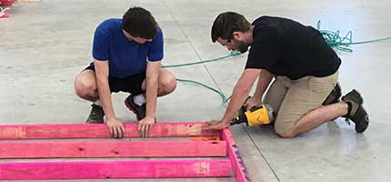 workers making furniture for container home